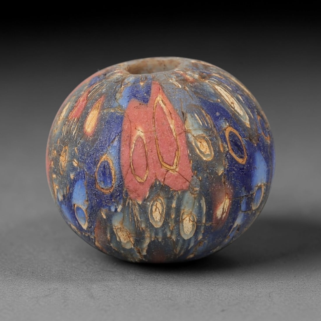 Ancient Glass Eye Bead - Egyptian Amulet Bead, 39ZM: This ancient bead is crafted from polychrome glass, formed using core-formed and trailed decorative techniques characteristic of Egyptian glassworking traditions. The spherical form features multiple