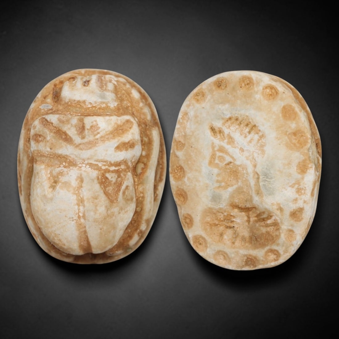 An Ancient Near Eastern Stone Scarab Stamp Seal, 1st Millennium BCE, 92AC: Carved from pale, weathered stone with natural surface encrustation and subtle tonal variation, the object is formed as an oval scarab seal. The dorsal side is modeled in low relief with a segmented c