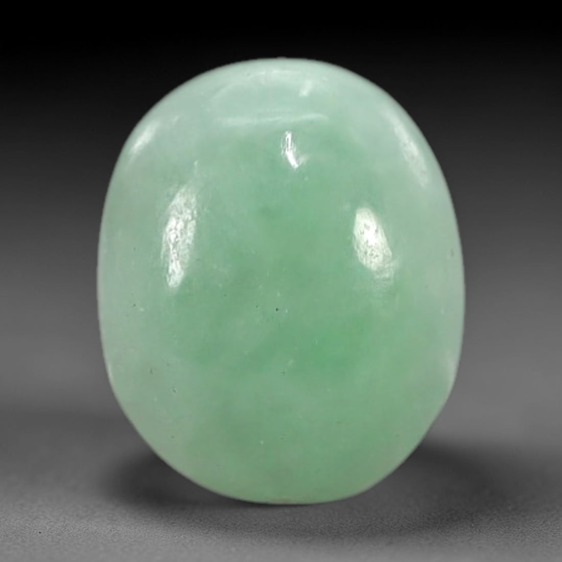2.14 Carats Apple Green Burmese Jadeite Jade Cabochon - Natural Loose Gemstone, 34XN: This singular Burmese jadeite jade cabochon presents a luminous apple green hue, soft and luminous with a translucent quality that allows light to filter gently through its smooth, domed surface. The