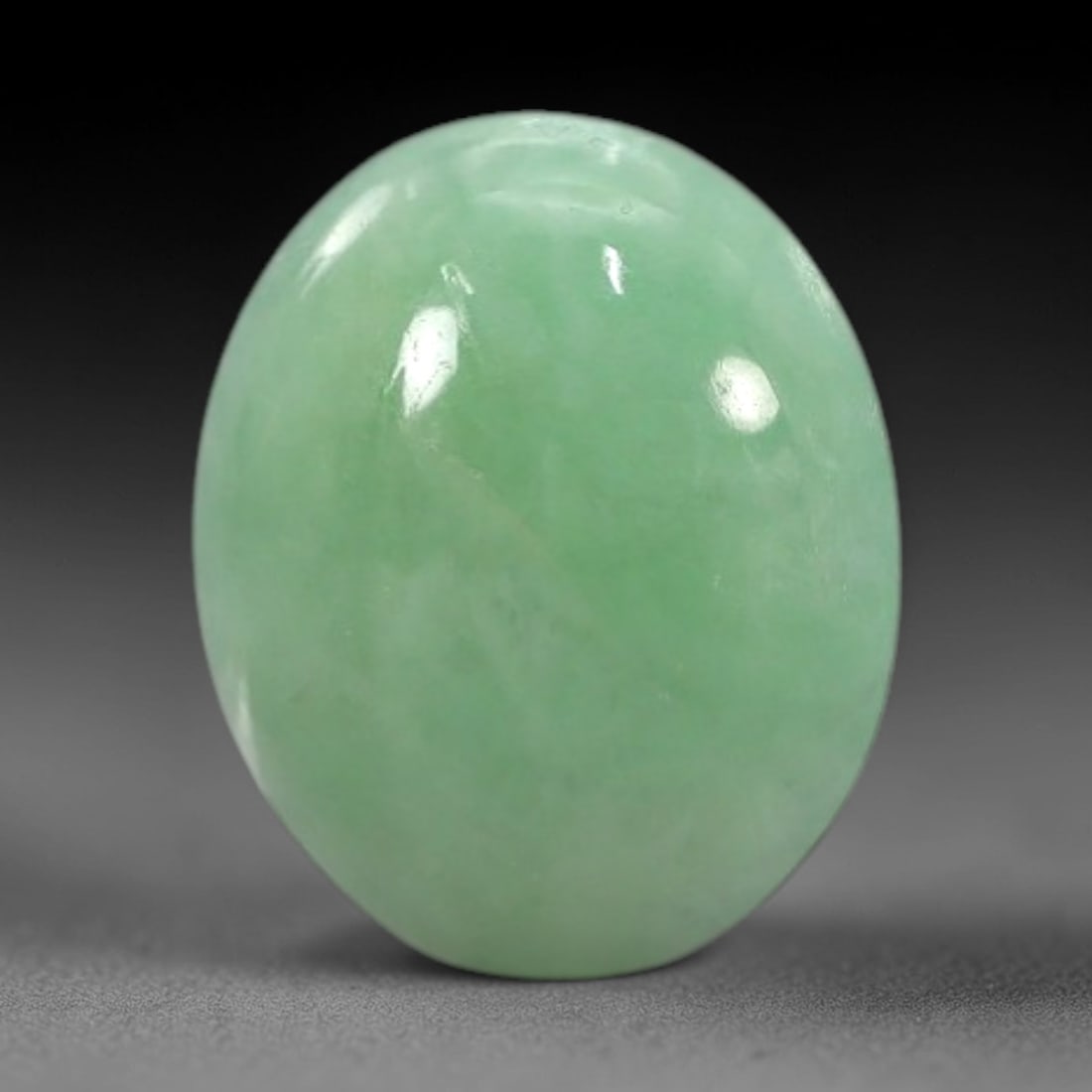2.18 Carats Apple Green Burmese Jadeite Jade Cabochon - Natural Loose Gemstone, 35XN: This singular Burmese jadeite jade cabochon presents a luminous apple green hue, soft and luminous with a translucent quality that allows light to filter gently through its smooth, domed surface. The