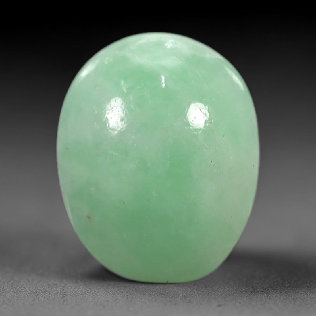 2.50 Carats Apple Green Burmese Jadeite Jade Cabochon - Natural Loose Gemstone, 64XN: This singular Burmese jadeite jade cabochon presents a luminous apple green hue, soft and luminous with a translucent quality that allows light to filter gently through its smooth, domed surface. The