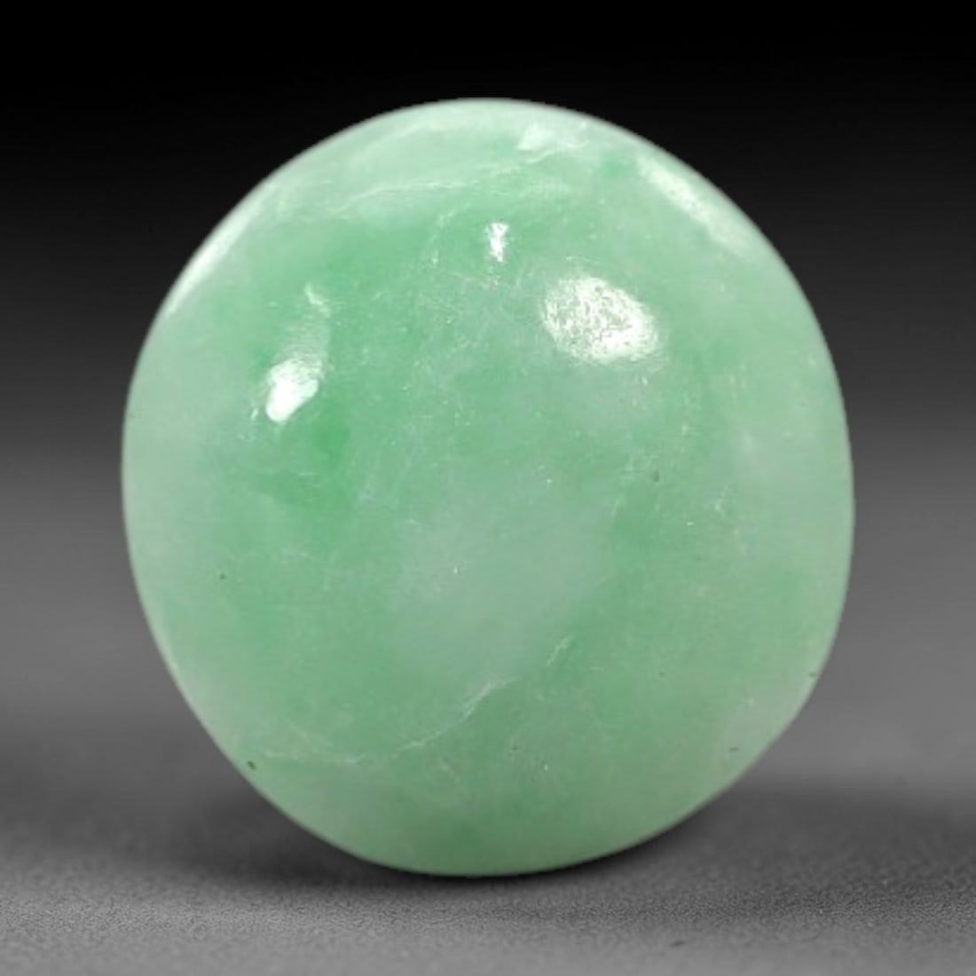 4.52 Carats Apple Green Burmese Jadeite Jade Cabochon - Natural Loose Gemstone, 83XN: This singular Burmese jadeite jade cabochon presents a luminous apple green hue, soft and luminous with a translucent quality that allows light to filter gently through its smooth, domed surface. The