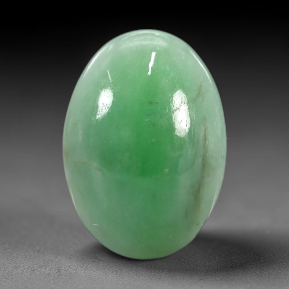 2.12 Carats Apple Green Burmese Jadeite Jade Cabochon - Natural Loose Gemstone, 73XN: This singular Burmese jadeite jade cabochon presents a luminous apple green hue, soft and luminous with a translucent quality that allows light to filter gently through its smooth, domed surface. The