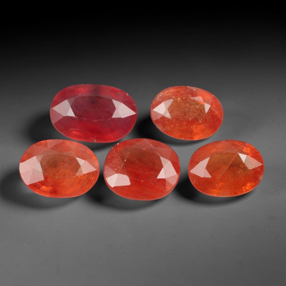4.27 Carats Warm Orange Sapphire Parcel - Natural Loose Gemstones, 98XN: This curated parcel of five oval-cut orange sapphires, weighing a total of 4.27 carats with individual dimensions ranging from 5.9 to 7.2 mm, showcases a rich spectrum of warm, earthy tones. From deep
