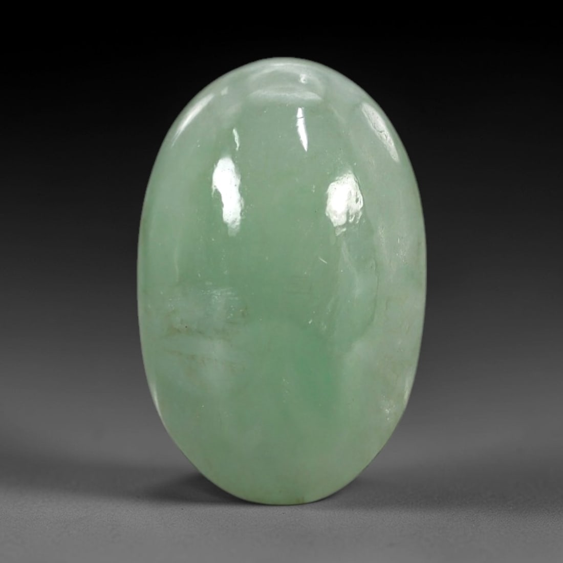 5.00 Carats Apple Green Burmese Jadeite Jade Cabochon - Natural Loose Gemstone, 60XN: This singular Burmese jadeite jade cabochon presents a luminous apple green hue, soft and luminous with a translucent quality that allows light to filter gently through its smooth, domed surface. The