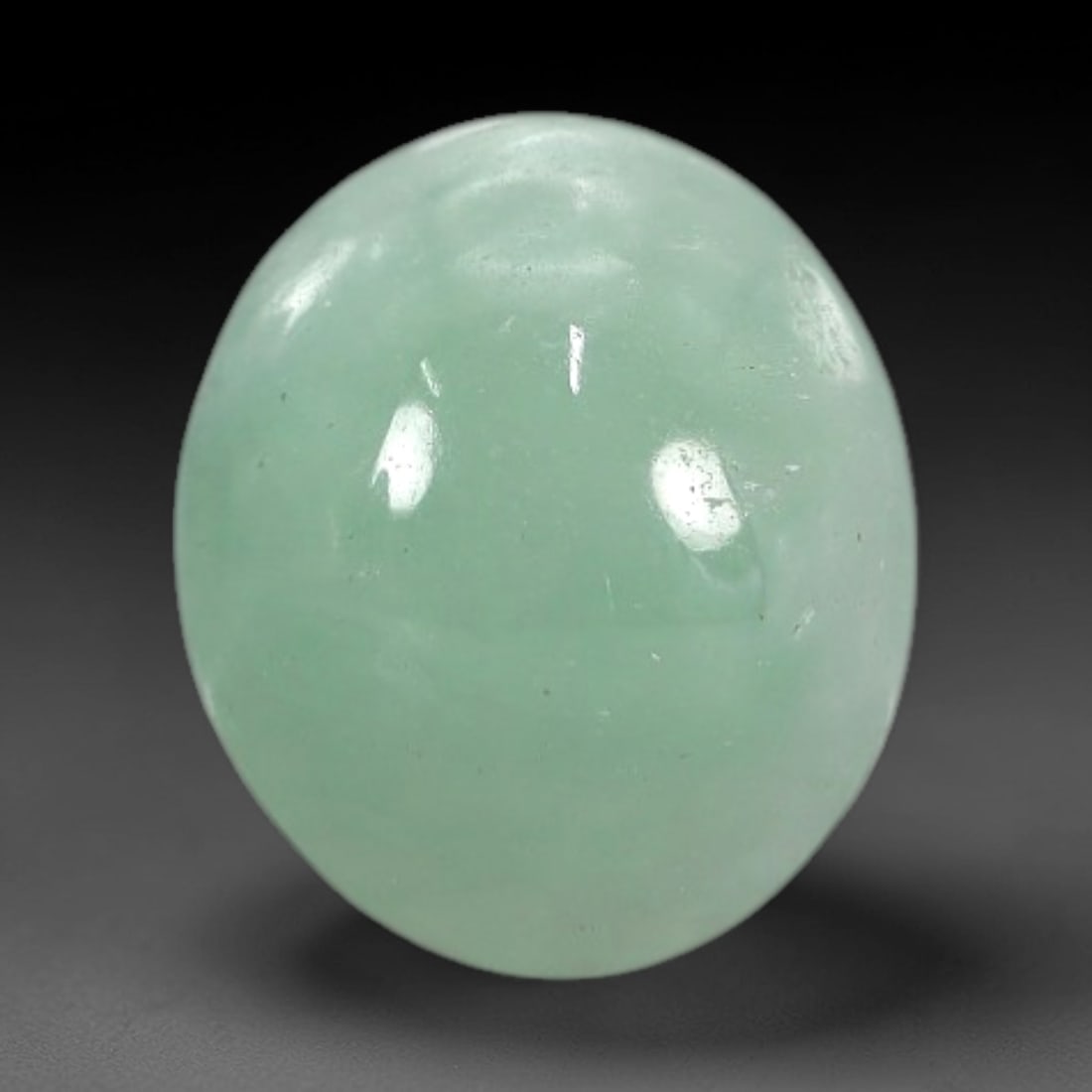 2.61 Carats Apple Green Burmese Jadeite Jade Cabochon - Natural Loose Gemstone, 42XN: This singular Burmese jadeite jade cabochon presents a luminous apple green hue, soft and luminous with a translucent quality that allows light to filter gently through its smooth, domed surface. The
