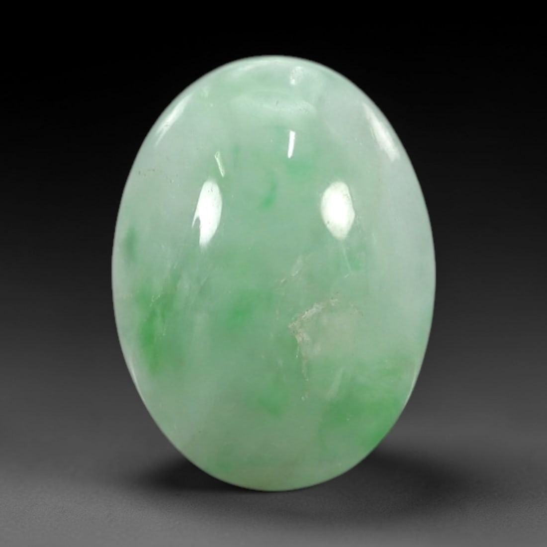 3.93 Carats Apple Green Burmese Jadeite Jade Cabochon - Natural Loose Gemstone, 65XN: This singular Burmese jadeite jade cabochon presents a luminous apple green hue, soft and luminous with a translucent quality that allows light to filter gently through its smooth, domed surface. The