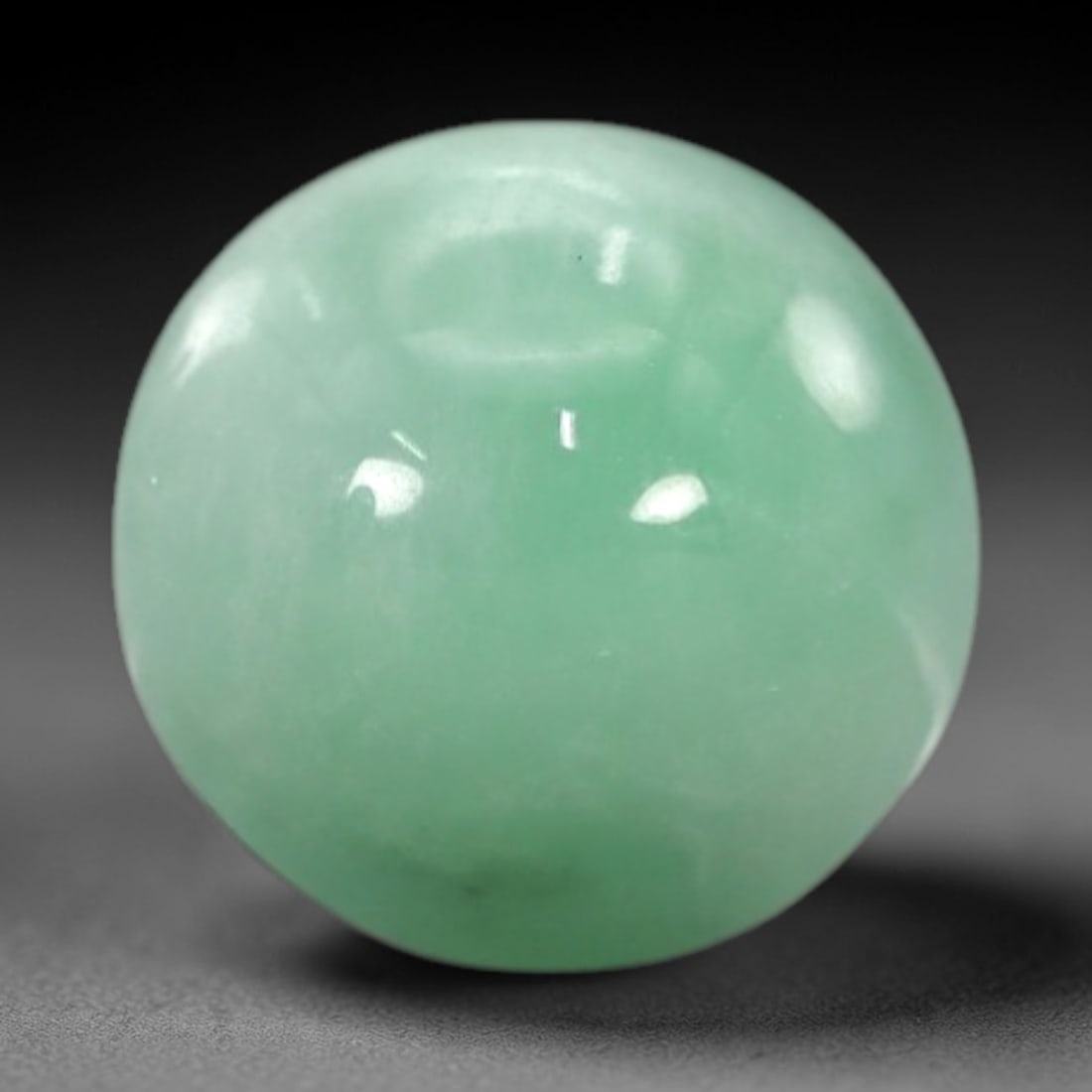 3.30 Carats Apple Green Burmese Jadeite Jade Cabochon - Natural Loose Gemstone, 63XN: This singular Burmese jadeite jade cabochon presents a luminous apple green hue, soft and luminous with a translucent quality that allows light to filter gently through its smooth, domed surface. The
