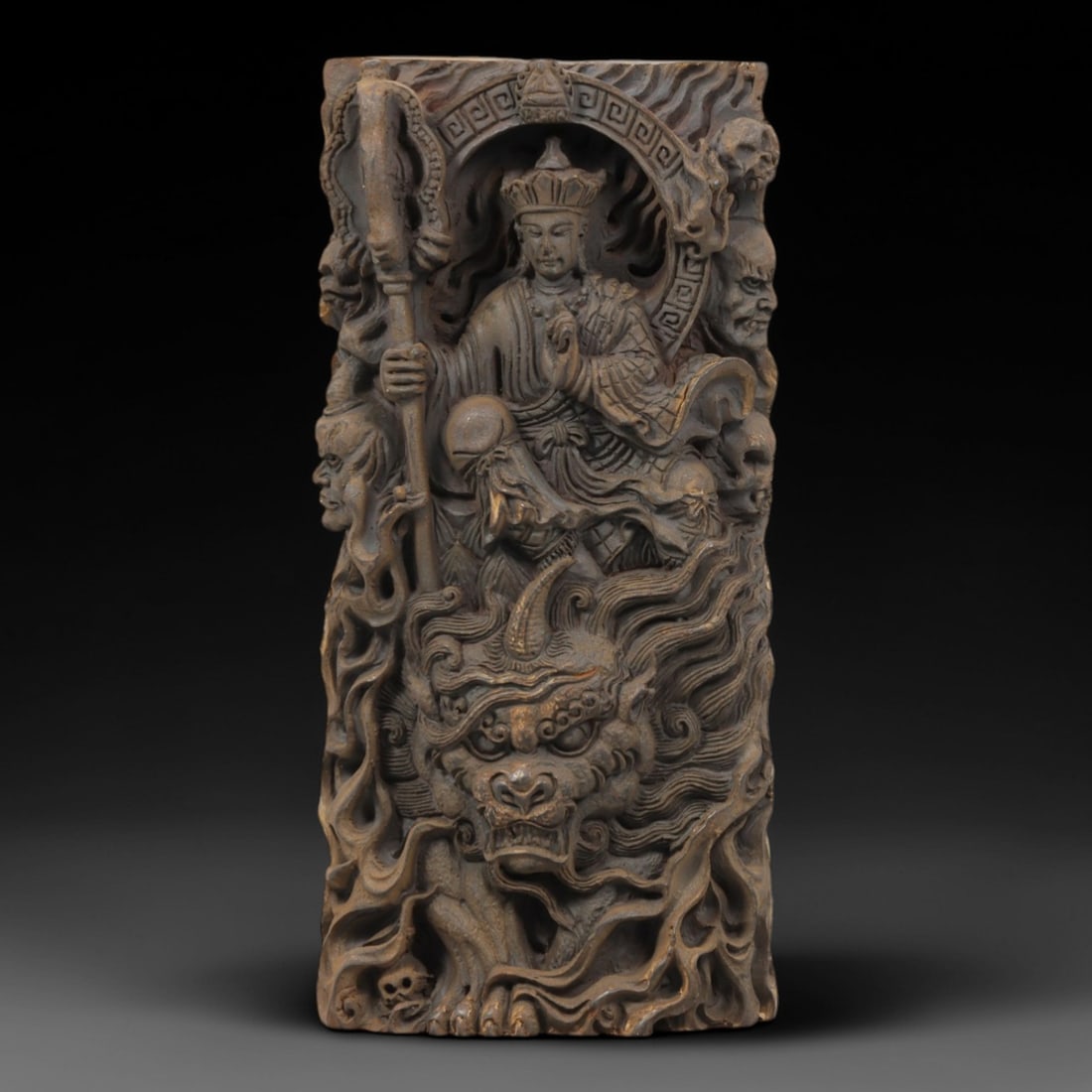 A Chinese Horn or Bone Buddhist Pendant Amulet, 20th Century, 86FV: Carved from horn or bone with a dark, aged patina and subtle tonal variations, the pendant is rectangular in form. The front face is deeply carved in high relief, depicting a seated Buddhist deity, li