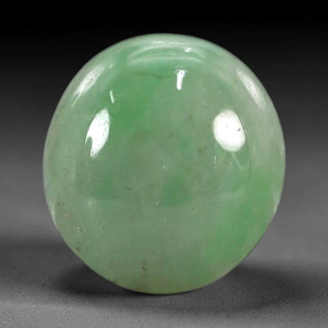 2.71 Carats Apple Green Burmese Jadeite Jade Cabochon - Natural Loose Gemstone, 45XN: This singular Burmese jadeite jade cabochon presents a luminous apple green hue, soft and luminous with a translucent quality that allows light to filter gently through its smooth, domed surface. The