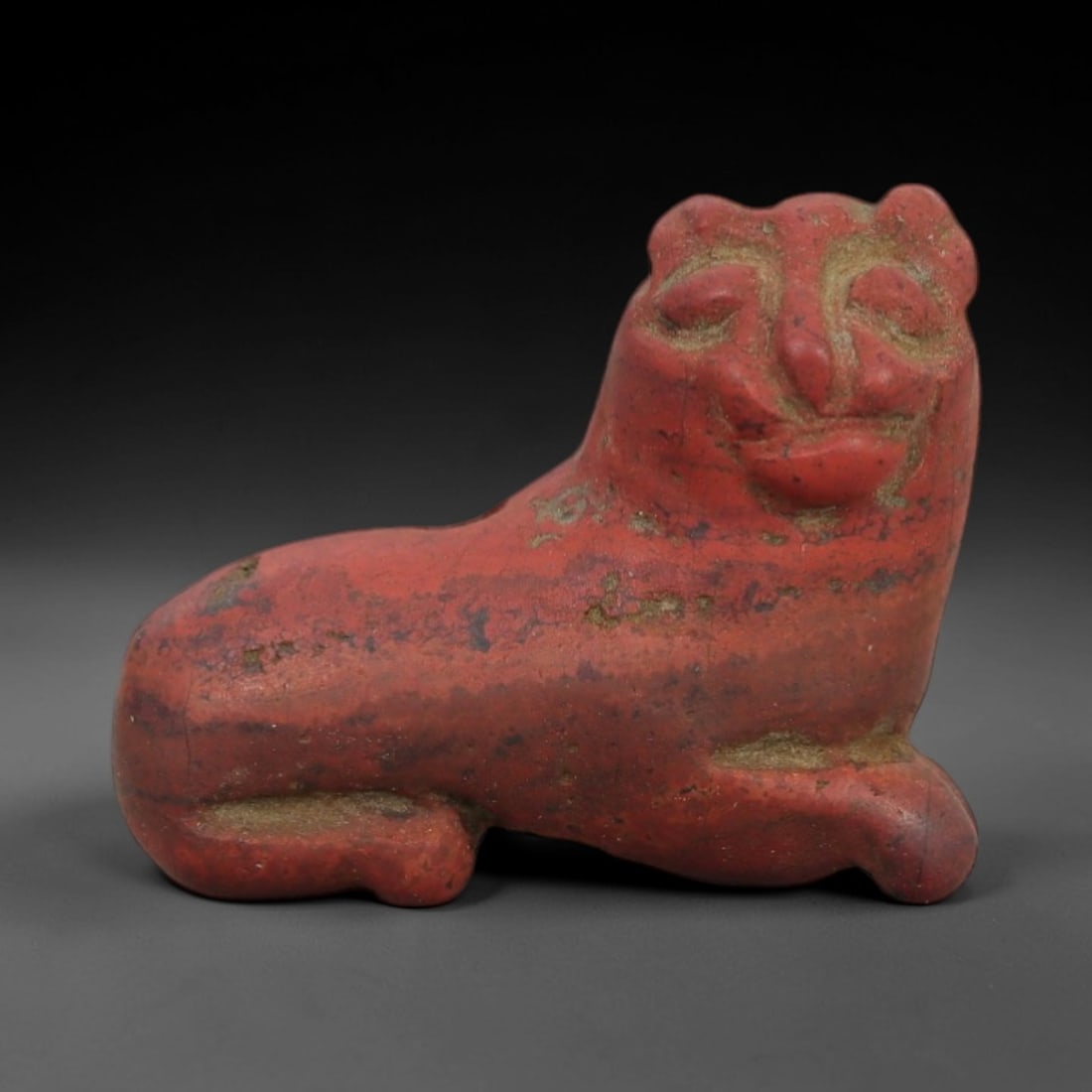 Ancient Red Stone Recumbent Bovid - Near Eastern Amulet, 100AD: Carved from rich red stone with natural mineral inclusions, this amulet depicts a recumbent bovid in a stylized, compact form. The creature is rendered in a resting posture, with simplified facial fea