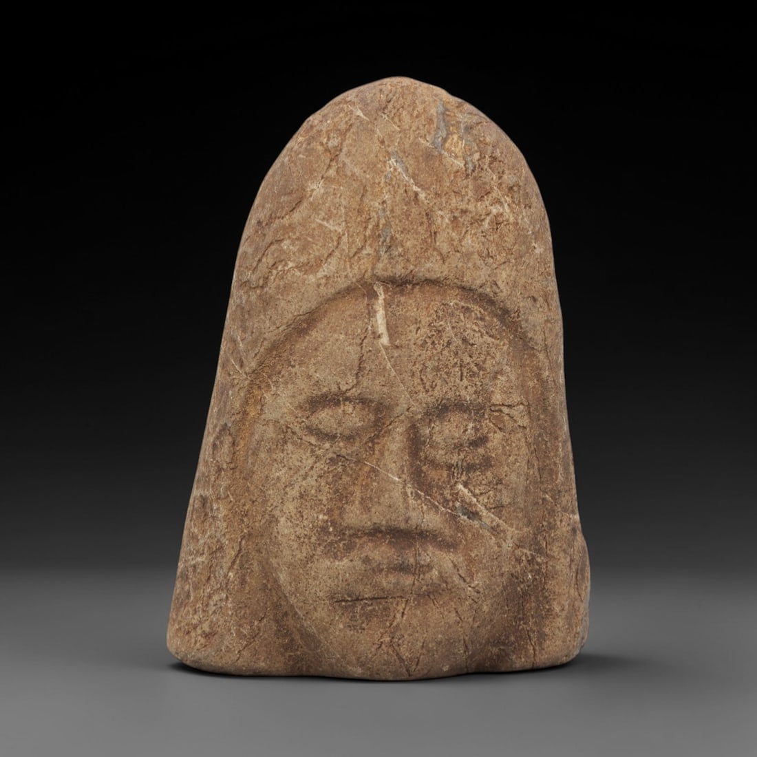 Ancient Steatite Bust - Near Eastern Maskette Figurine, 89FW: Carved from steatite, this bust maskette exhibits the characteristic rough, textured surface of ancient Near Eastern stoneworking, with incised lines defining the facial features and a hooded upper fo