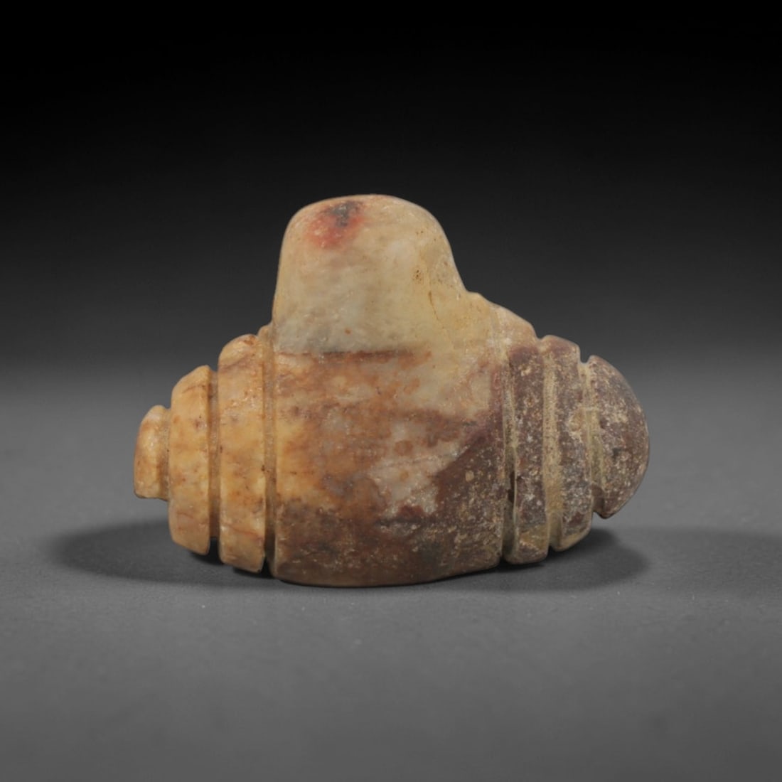 Ancient Tan Stone Segmented Pendant - Near Eastern Ritual Amulet, 17XQ: Carved from a warm, earthy tan stone with natural reddish-brown mineral inclusions, this miniature pendant features a highly stylized segmented form, a distinctive geometric motif in ancient Near East