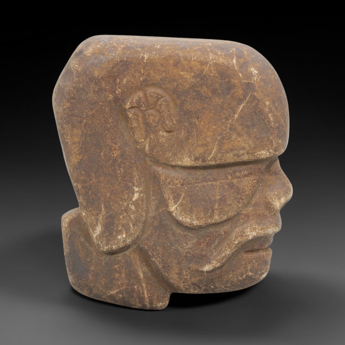 Ancient Stone Tribal Head - Ritual Anthropomorphic Figurine, 41FX: Carved from a dense, earthy-brown stone with a granular matrix and natural calcite veining, this artifact depicts a stylized tribal head in profile, featuring a prominent squared cranial form, incised