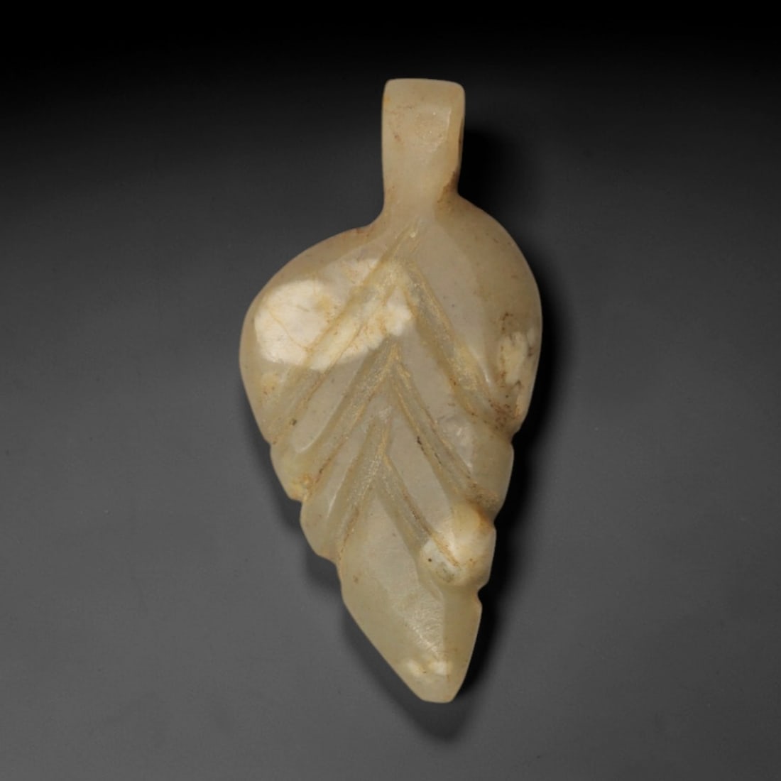 Ancient Cream Stone Leaf-Form Pendant - Near Eastern Ritual Amulet, 85XP: Carved from a translucent, creamy-tan stone with natural mineral veining, this delicate pendant takes the stylized form of a leaf, a beloved motif in ancient Near Eastern ritual art associated with gr