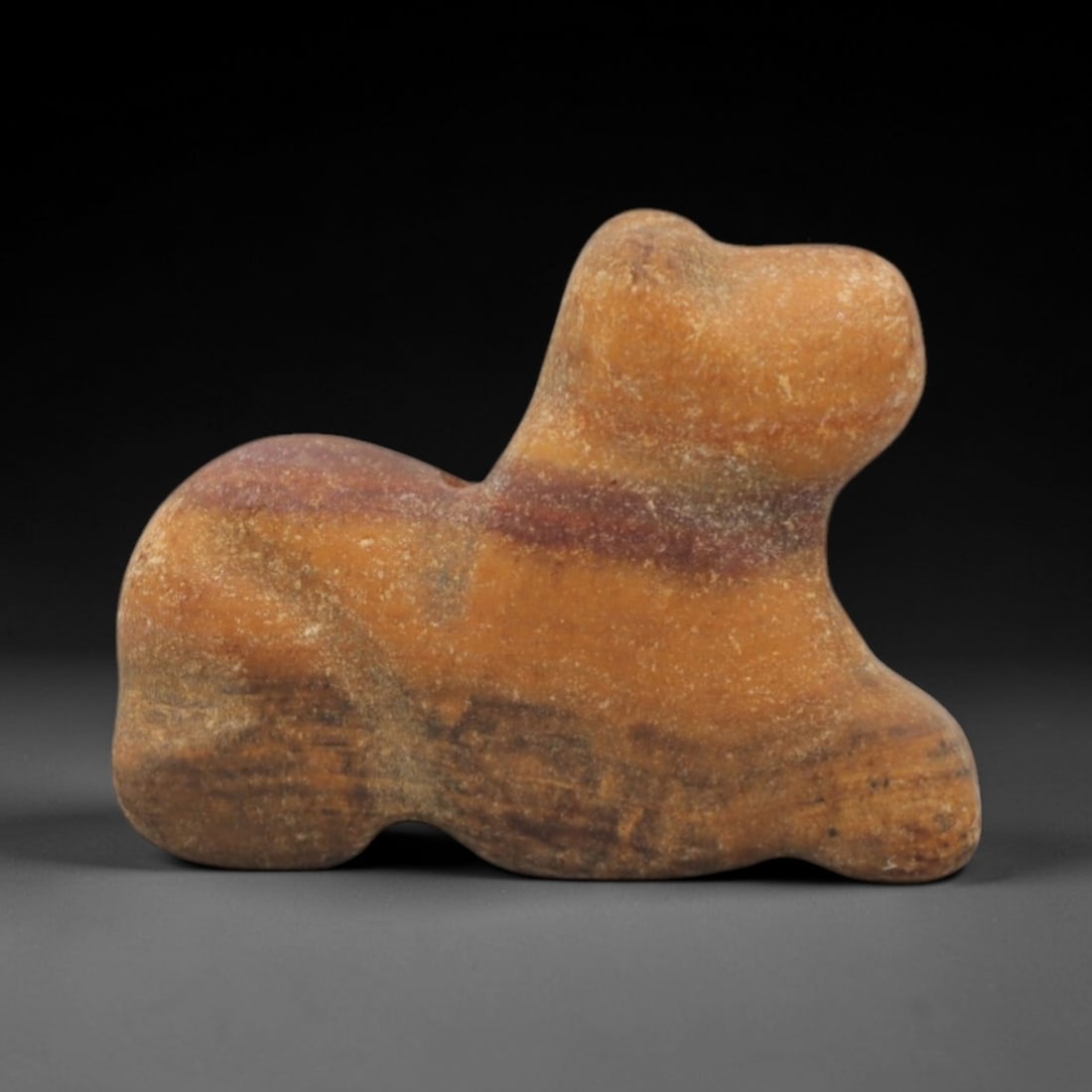 Ancient Banded Stone Animal - Near Eastern Zoomorphic Amulet, 64XP: Carved from beautifully banded agate or similar stone, this miniature zoomorphic amulet depicts a stylized recumbent animal, likely a feline or small ungulate, a classic motif in ancient Near Eastern