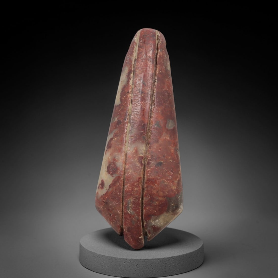 Ancient Red Stone Plumb Amulet - Near Eastern Pendant, 18AE: This artifact is a carved red stone plumb amulet of Near Eastern origin, crafted from a rich terracotta-hued stone with natural pale mineral inclusions and earthy patination. Its elongated, tapering f