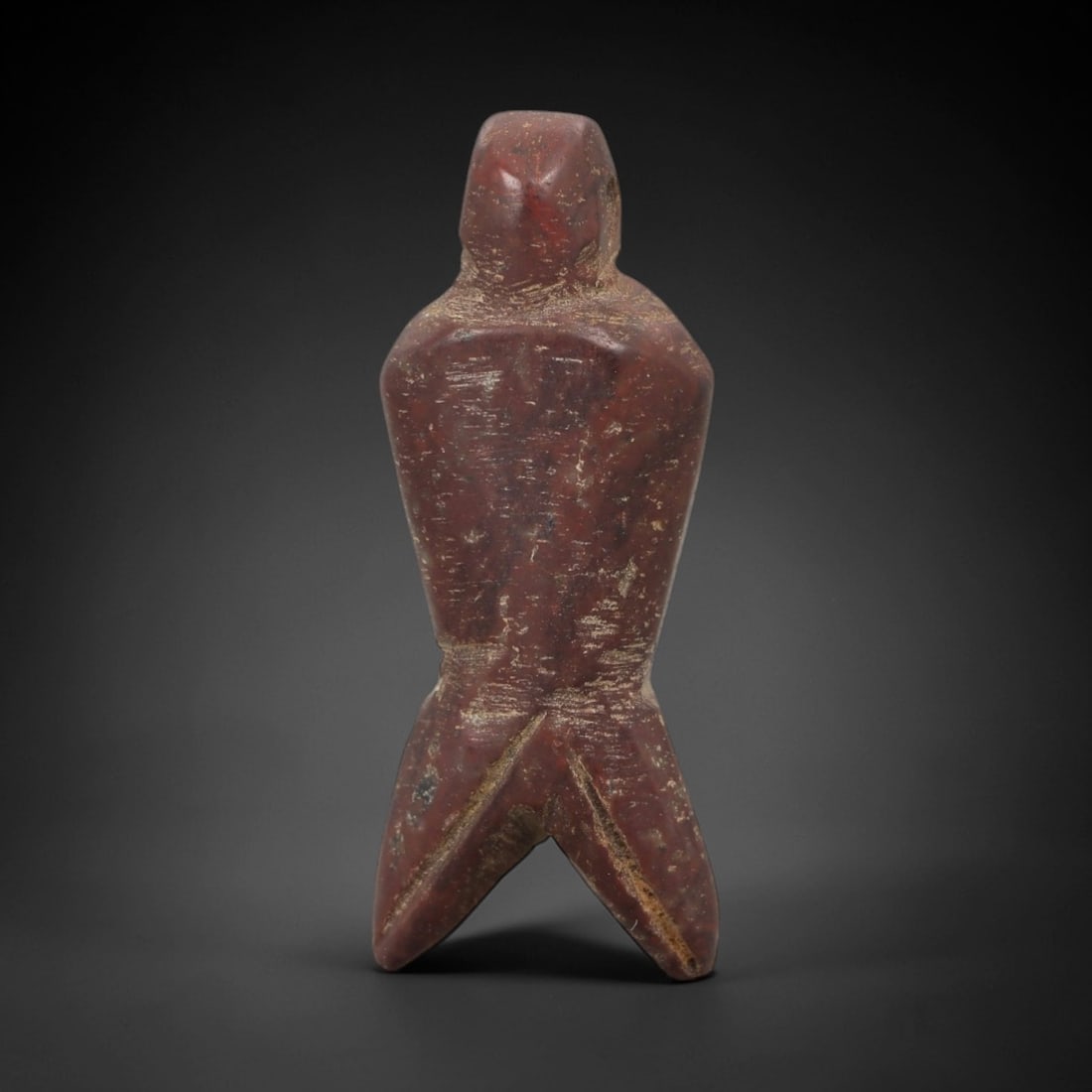 Ancient Egyptian Stone Amulet - Anthropomorphic Carved Pendant, 29AE: Carved from reddish-brown stone, this ancient Egyptian amulet features an anthropomorphic form with a suspension hole at the top and a three-pronged base, a motif typical of Egyptian protective amulet