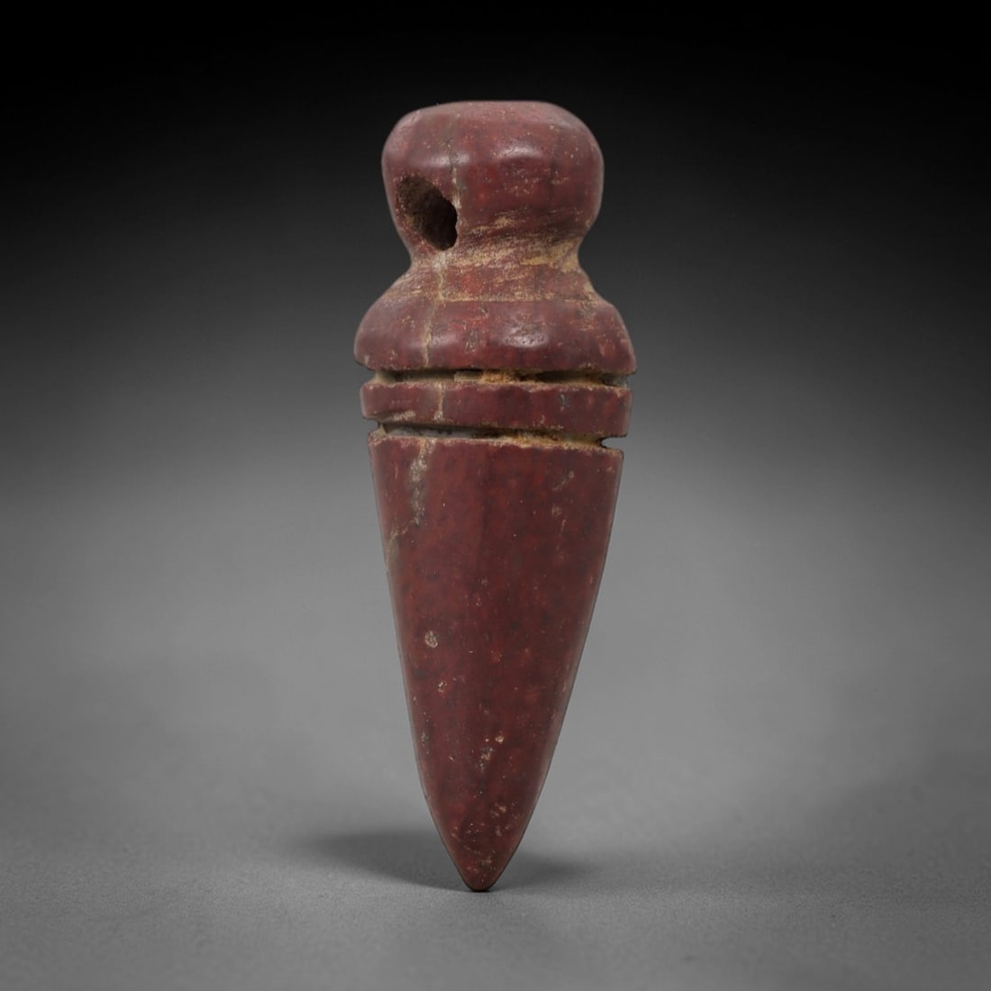 Ancient Red Stone Plumb Amulet - Near Eastern Pendant, 76AG: This artifact is a carved red stone amulet of Near Eastern origin, crafted from a rich terracotta-hued stone with natural surface striations and mineral inclusions. Its form consists of a rounded uppe