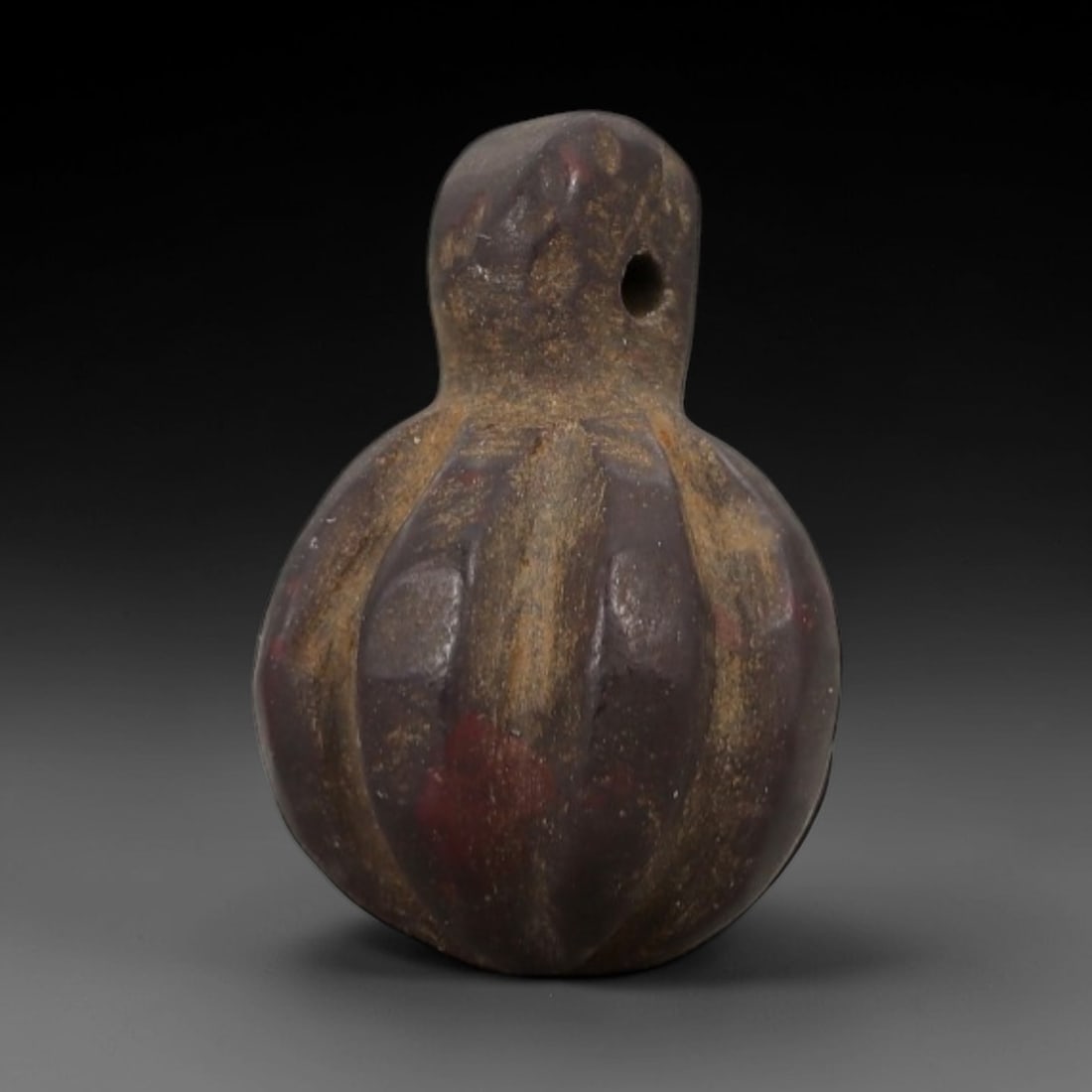 Ancient Stone Pomegranate Amulet - Near Eastern Ritual Figurine, 64AG: This amulet is carved from a single piece of deep reddish-brown stone, exhibiting a granular texture with earthy ochre patina and subtle red mineral inclusions across its surface. The form is stylized