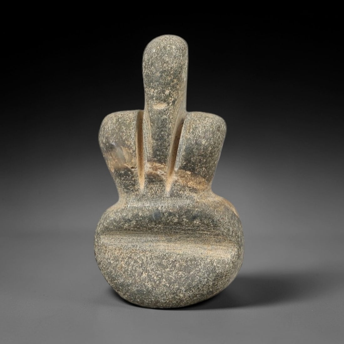 Ancient Stone Tyet Amulet - Egyptian Ritual Figurine, 25AG: This amulet is carved from a single piece of mottled grey-green stone, exhibiting a granular texture with subtle ochre patina and natural mineral flecks across its surface. The form is a stylized Tyet