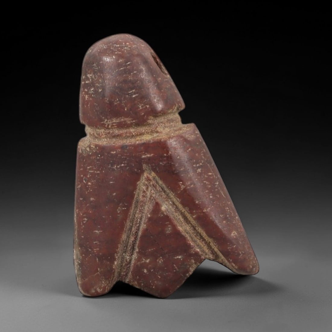 Ancient Egyptian Stone Amulet - Carved Ritual Figurine, 17AG: Carved from reddish-brown stone, this amulet features incised linear patterns on its upper section and a tapered, notched base. The form is consistent with small Egyptian ritual amulets of the Late Pe