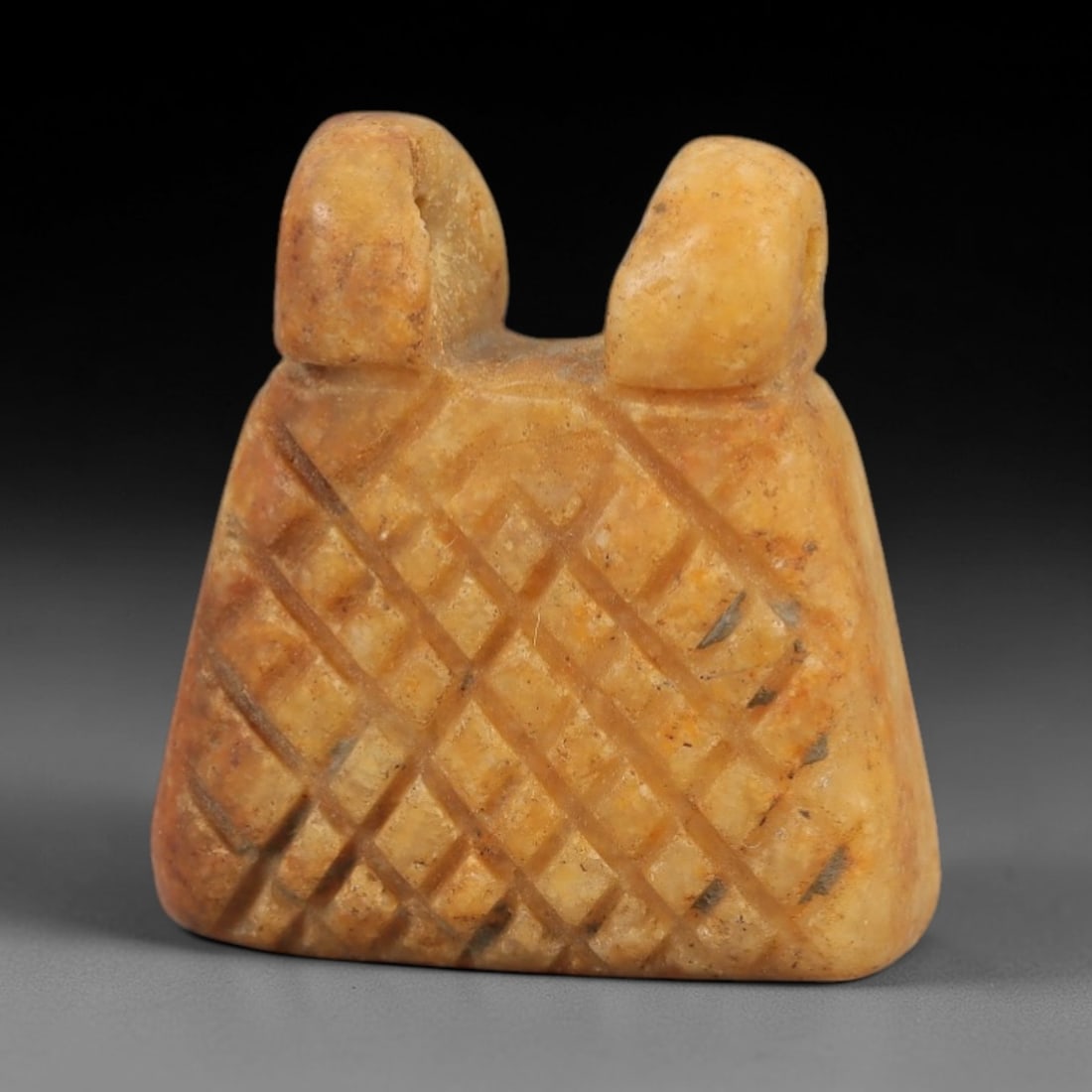 Ancient Egyptian Stone Amulet - Carved Ritual Pendant, 75AE: Carved from beige stone, this amulet features a geometric grid pattern with a suspension loop at the top, consistent with ancient Egyptian ritual pendants of the Late Period. The form is designed for