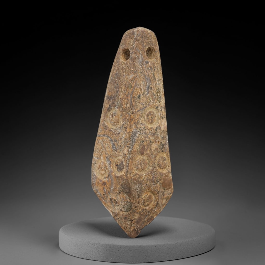 Ancient Egyptian Stone Amulet - Linear Circular Motifs, 96AE: Carved from stone, this ancient Egyptian amulet features a series of circular motifs arranged in a linear pattern, a design typical of protective amulets from the Late Period (c. 664-332 BCE). The cir