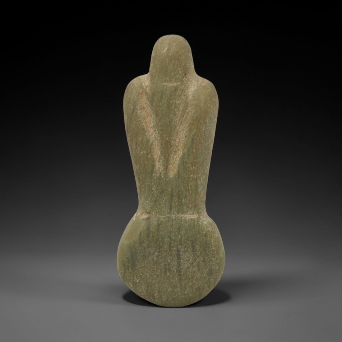 Ancient Stone Anthropomorphic Amulet - Near Eastern Figurine, 47XQ: This amulet is carved from a smooth, greenish-gray stone, shaped into an abstract anthropomorphic form with a rounded head, narrow torso, and broad, rounded lower section, lacking perforations and sug