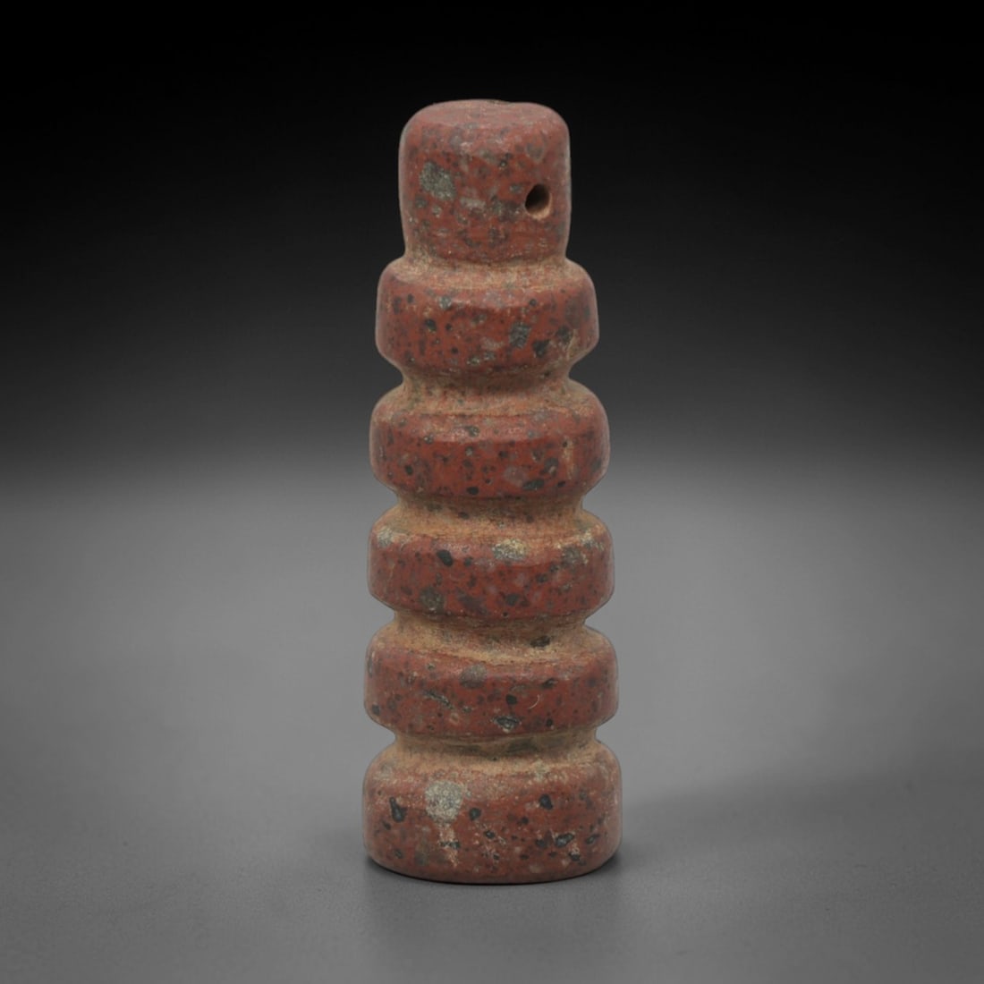 Ancient Egyptian Stone Segmented Amulet - Egyptian Pendant, 56XQ: This amulet is carved from a speckled, reddish-brown stone, shaped into a tall, cylindrical form with five distinct, rounded horizontal segments, and a perforated suspension hole at the upper tip, con