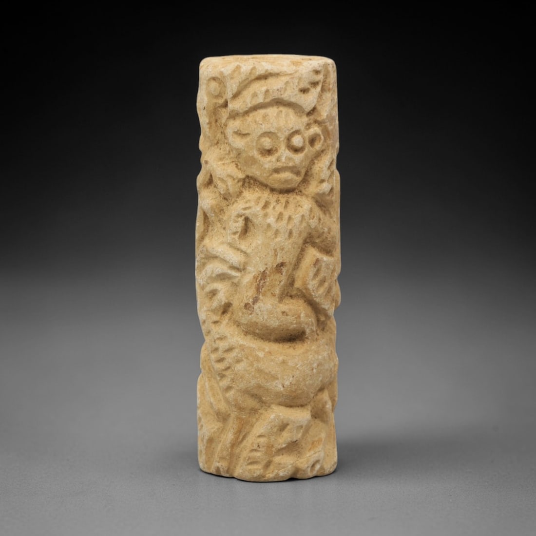 Ancient Limestone Anthropomorphic Bead - Near Eastern Carved Relief, 87ZQ: Carved from limestone, this ancient Near Eastern bead features a raised relief anthropomorphic motif with detailed facial features and stylized body ornamentation along its cylindrical form. The carvi