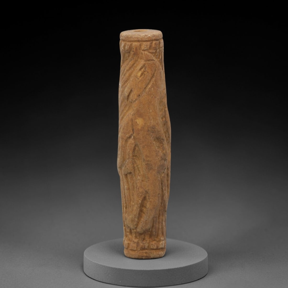 Ancient Limestone Cylinder Bead - Near Eastern Carved Relief, 89ZQ: Carved from limestone, this ancient Near Eastern cylinder bead features raised relief detailing along its cylindrical form, depicting stylized humanoid figures and geometric patterns typical of region