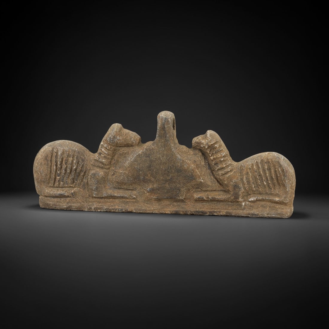 Ancient Steatite Achaemenid Amulet - Zoomorphic Carving, 89AG: Carved from steatite stone, this ancient Achaemenid amulet pendant features three stylized ram heads in a row, a motif characteristic of Achaemenid glyptic art. The carving displays fine detail in the