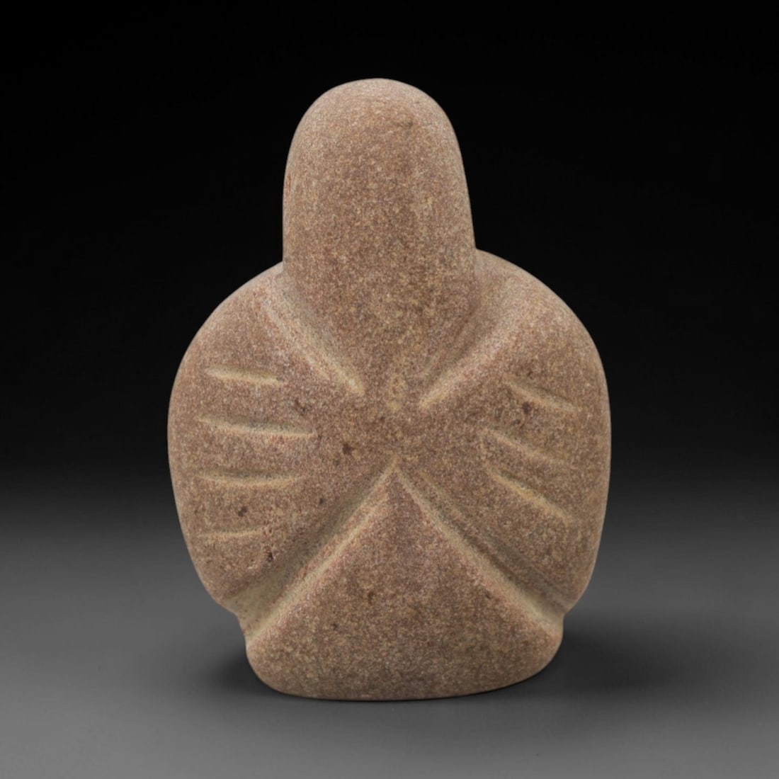 Ancient Stone Abstract Winged Figurine - Near Eastern Idol, 70XQ: Carved from a warm, speckled brown stone, this artifact depicts a highly stylized abstract figurine with a rounded head, broad wing-like lateral extensions, and a tapering base. Incised radiating line