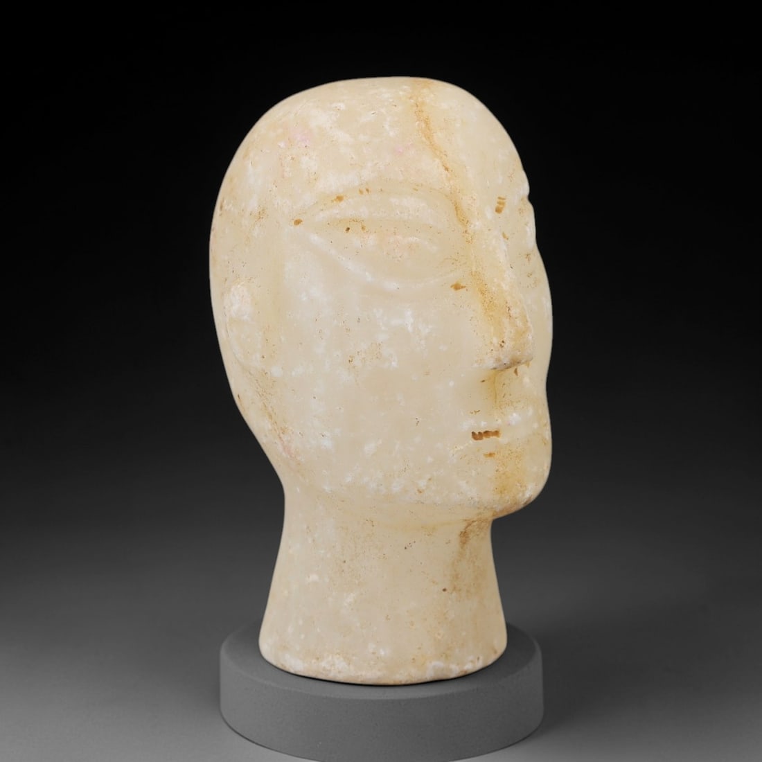 Ancient Calcite Bust - Bactrian Idol Head, 52AH: Carved from calcite, this ancient Bactrian idol head is a complete bust featuring a stylized human facial form with detailed eye sockets and subtle facial features typical of Bactrian artistic traditi