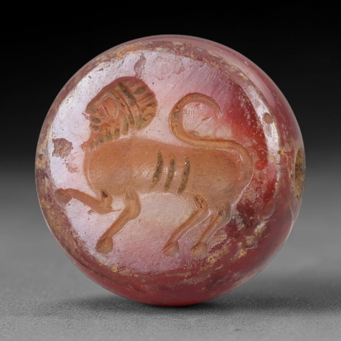 Ancient Agate Stamp Seal - Bead Amulet, 10AH: Carved from agate, this ancient stamp seal features a raised relief of a stylized animal motif on the upper surface, with a central perforation for suspension, functioning as both a seal and a bead am
