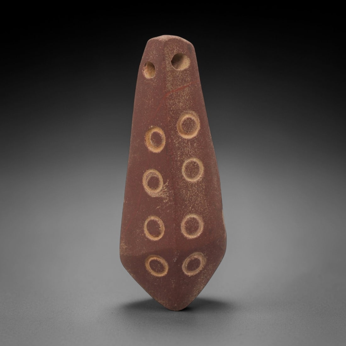 Ancient Stone Eight-Dot Amulet - Egyptian Pendant, 77XQ: Carved from a rich reddish stone, this amulet takes an elongated, tapering form with two perforations at the top for suspension, its surface incised with eight circular dot motifs arranged in four ver
