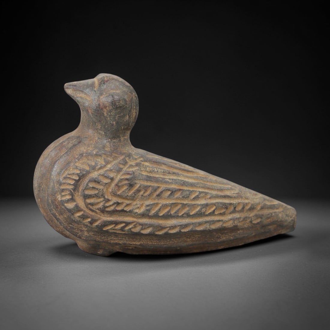 Ancient Steatite Bird Amulet - Zoomorphic Carving, 88AG: Carved from steatite stone, this ancient zoomorphic amulet takes the form of a stylized bird with detailed feather patterns and a compact body, reflecting Near Eastern glyptic art traditions. The carv