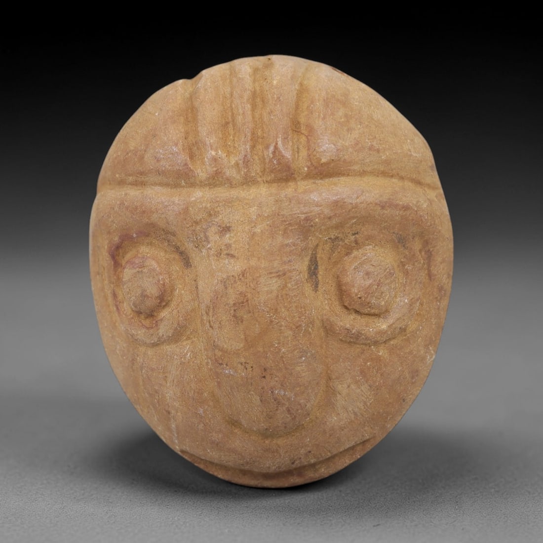 Ancient Steatite Eye Amulet - Anthropomorphic Carving, 87AG: Carved from steatite stone, this ancient amulet features an anthropomorphic face with prominent, detailed eye motifs, a hallmark of Near Eastern ritual iconography. The carving exhibits primitive yet