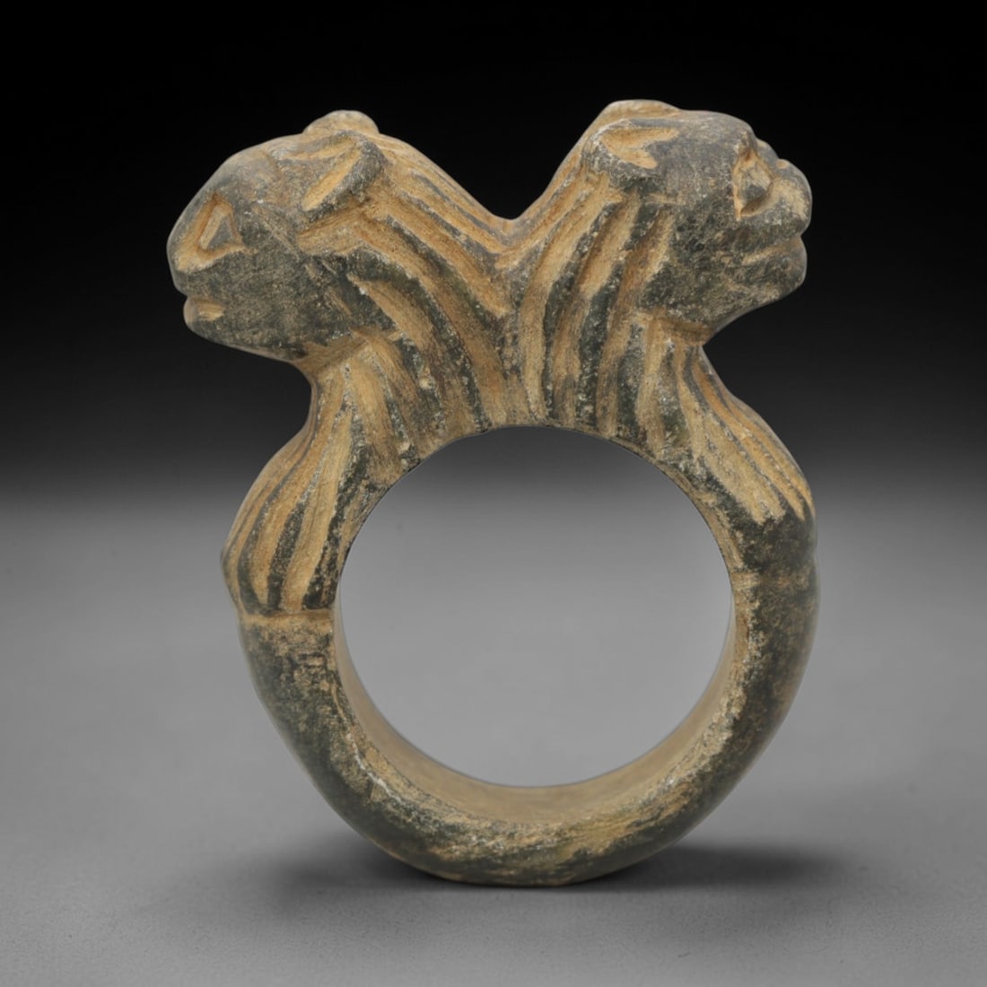 Ancient Steatite Ring - Achaemenid Double Feline Signet Ring, 33ZQ: Carved from steatite, this ancient Achaemenid ring features a double feline head motif with linear detailing, characteristic of Achaemenid glyptic art. The ring exhibits a smooth, aged patina consiste