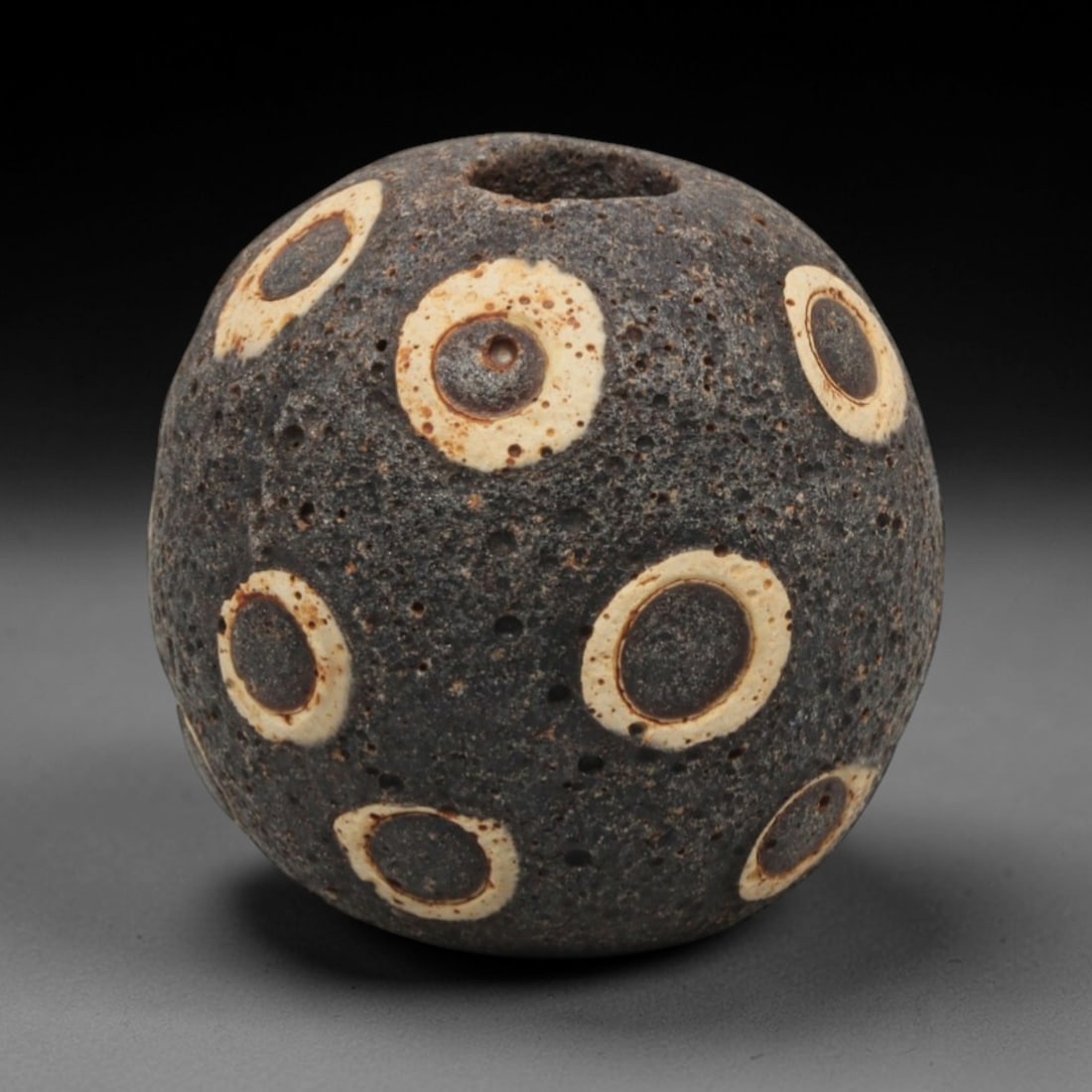Ancient Islamic Glass Bead - Mosaic Eye Bead, 40ZN: Crafted from ancient glass, this Islamic period bead features a mosaic pattern with layered white, yellow, and brown glass trails applied to a dark base, characteristic of decorative glassmaking techn