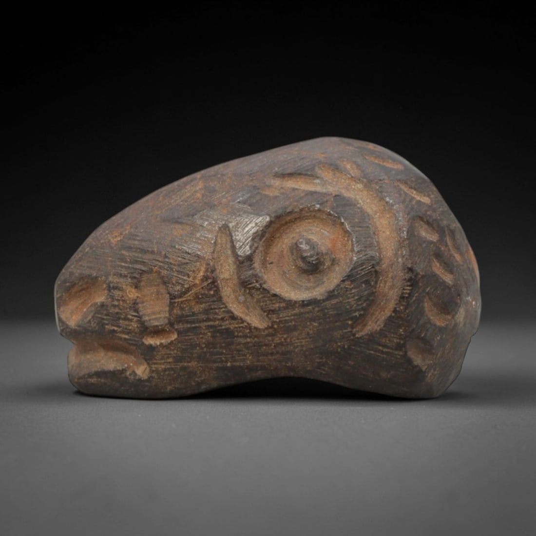 Ancient Hematite Ram Head Bead - Near Eastern Amulet, 6ZQ: Carved from hematite, this ancient Near Eastern ram head bead features a stylized facial rendering with distinct eye and horn details, crafted in the primitive yet expressive style typical of regional