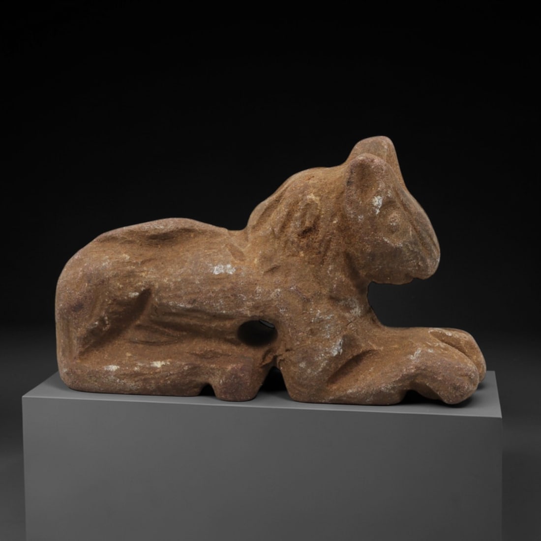 Ancient Limestone Feline Amulet - Near Eastern Figurine, 41ZQ: Carved from limestone, this small feline amulet exhibits a simplified, stylized form with incised detailing for facial features and body texture. The stone has a warm, earthy patina with minor surface