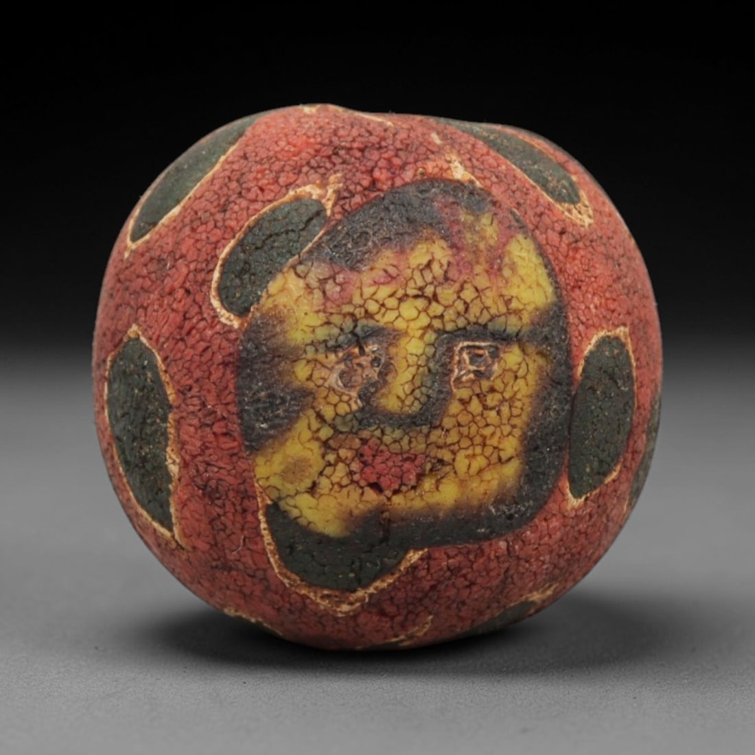 Ancient Glass Bead - Roman Egyptian Mosaic Amulet, 63ZN: Crafted from mosaic glass, this spherical bead features a central suspension hole and is decorated with bold circular motifs in red, yellow, and dark green glass inlay, characteristic of Roman-Egyptia