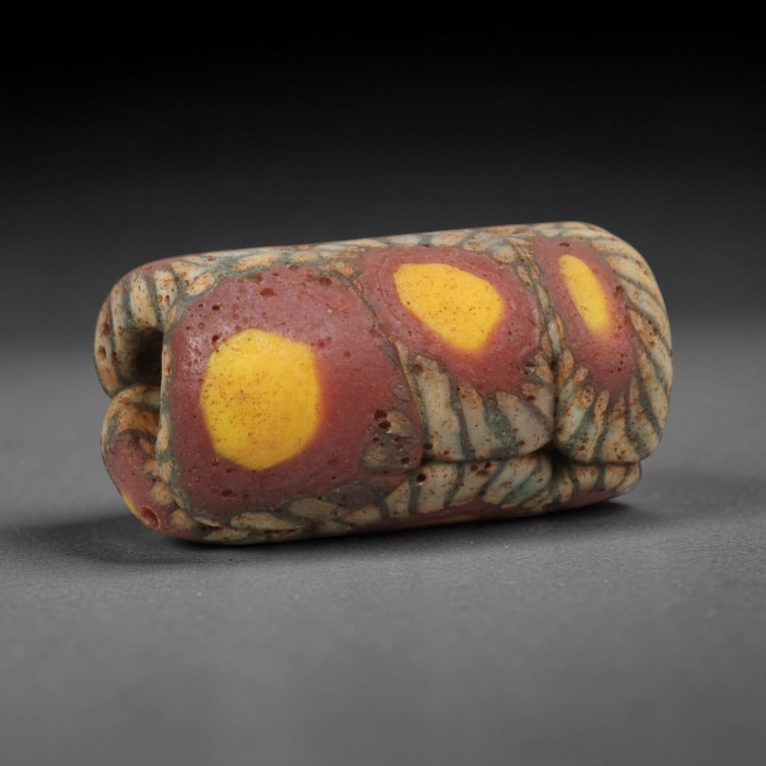 Ancient Islamic Glass Bead - Mosaic Trade Bead, 87ZN: Crafted from ancient glass, this Islamic period bead features a mosaic pattern with layered red, yellow, and white glass trails applied to a translucent base, characteristic of early Islamic decorativ