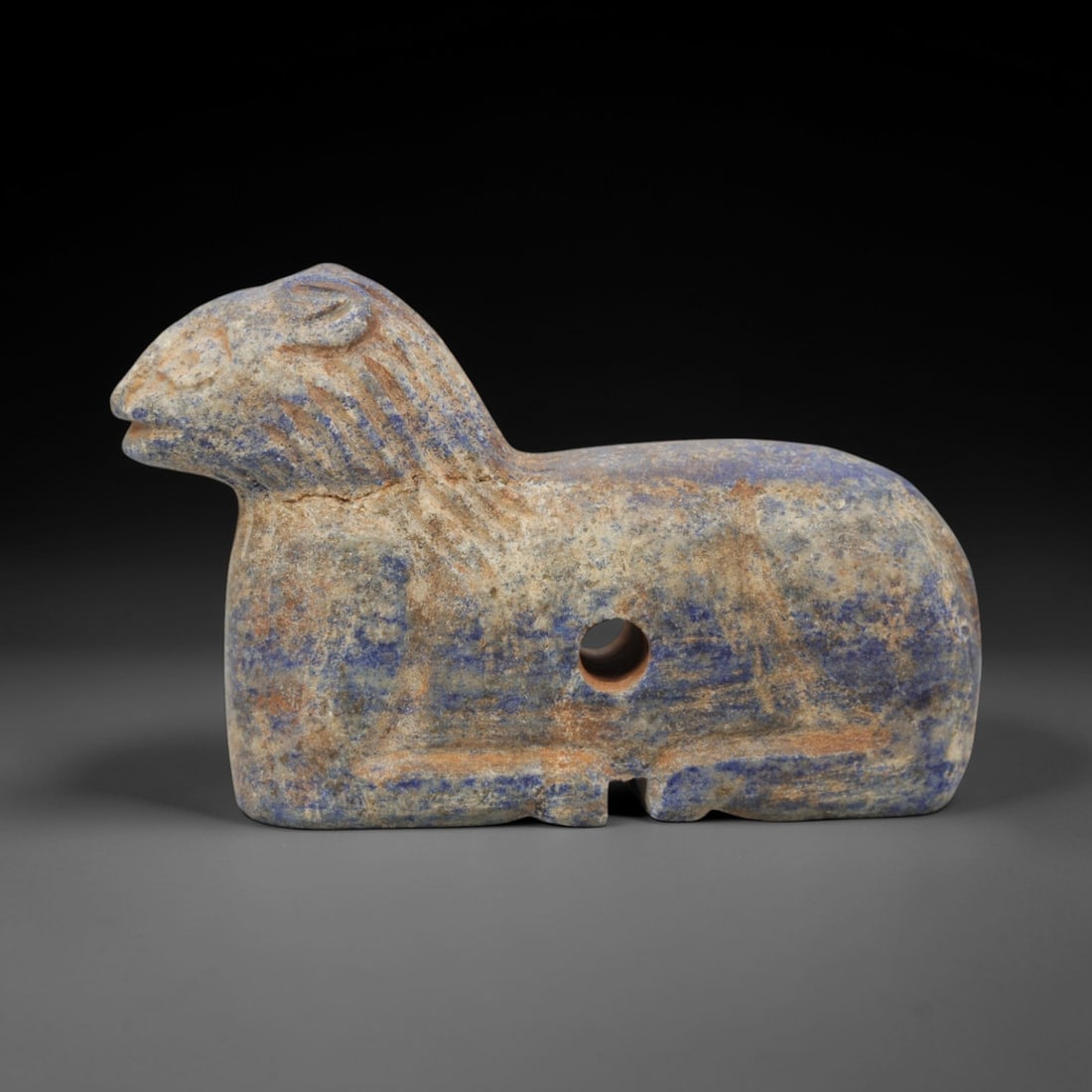 Ancient Lapis Lazuli Feline Amulet - Near Eastern Figurine, 61ZQ: Carved from deep blue lapis lazuli, this feline amulet features a stylized recumbent form with incised detailing for facial features and body texture. The stone exhibits natural pyrite inclusions and
