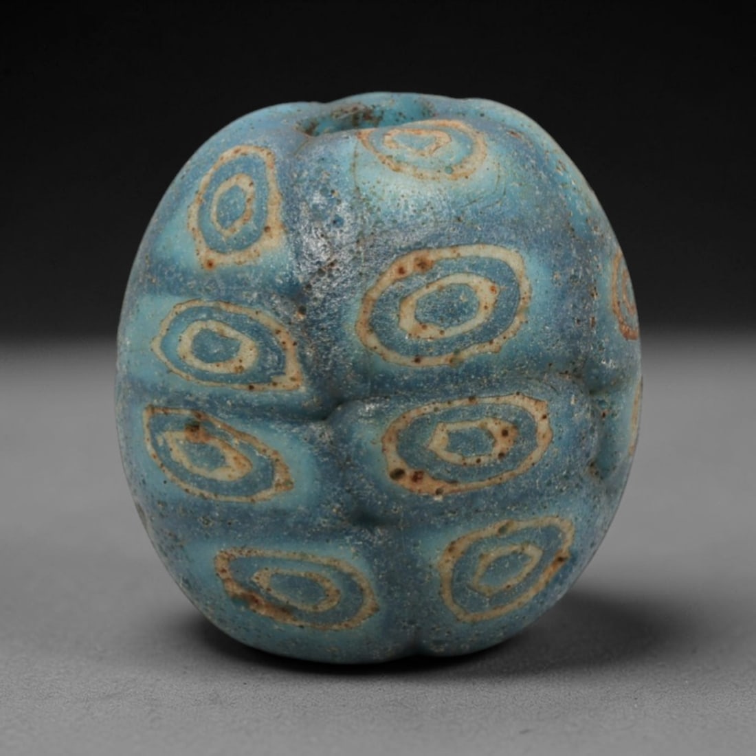 Ancient Islamic Glass Bead - Mosaic Eye Trade Bead, 88ZN: Crafted from ancient glass, this Islamic period bead features a mosaic eye pattern with layered blue, yellow, and white glass trails applied to a translucent base, characteristic of decorative glassma
