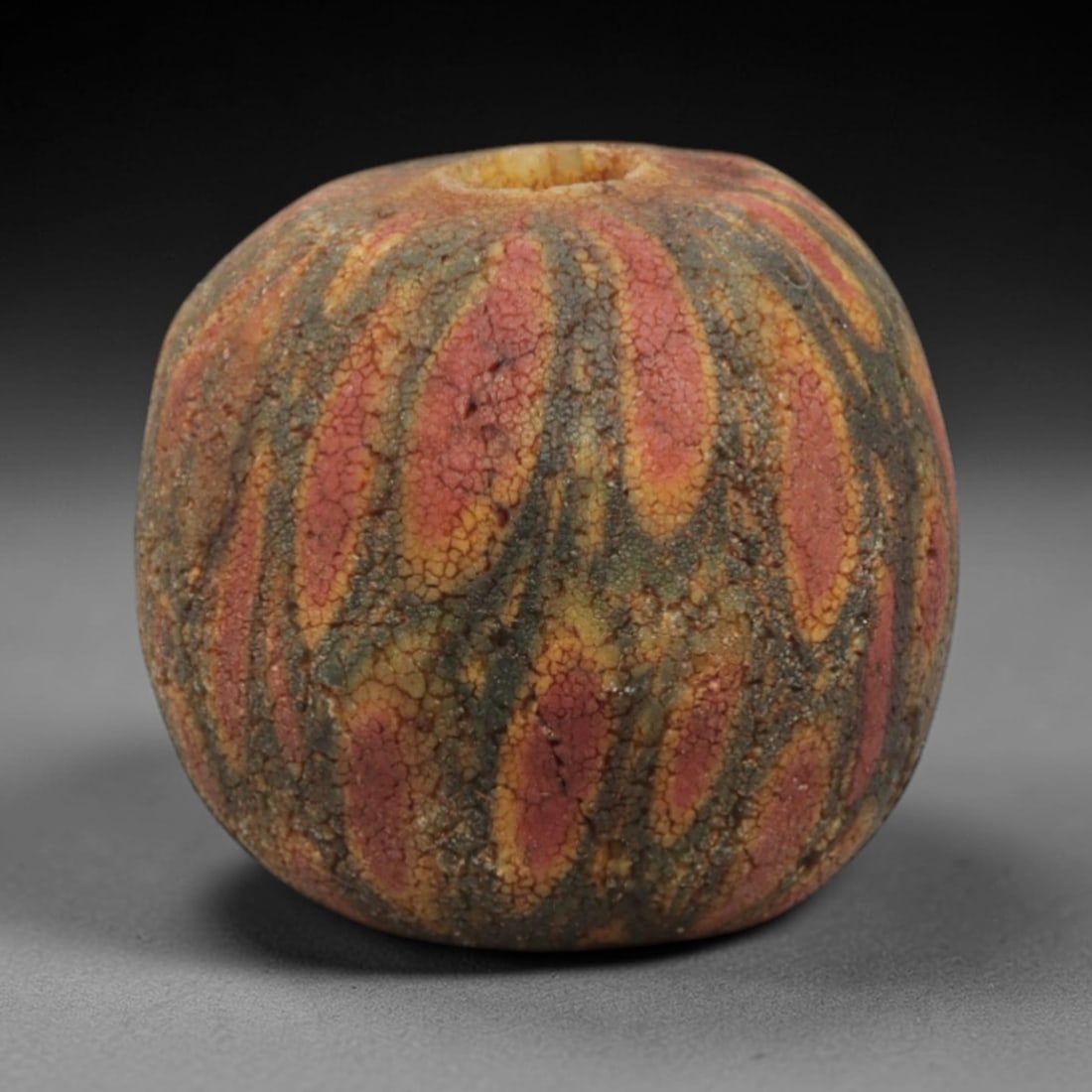 Ancient Islamic Glass Bead - Swirled Mosaic Trade Bead, 47ZN: Crafted from ancient glass, this Islamic period bead features a swirled mosaic pattern with layered red, yellow, and green glass trails applied to a translucent base, characteristic of decorative glas