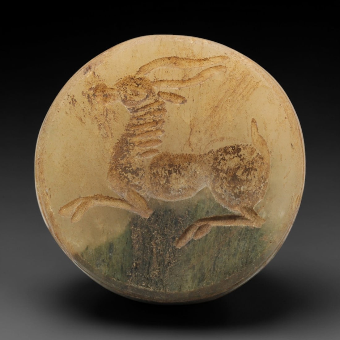 Ancient Steatite Hemispherical Stamp Seal - Near Eastern Amulet, 72ZQ: Carved from steatite, this hemispherical stamp seal features a stylized running stag motif with incised linear detailing on the convex face. The stone exhibits a soft, earthy patina with minor surface