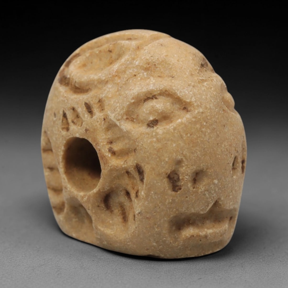 Ancient Limestone Humanoid Stamp Seal - Near Eastern Hemispherical Seal, 4ZQ: Carved from limestone, this ancient Near Eastern hemispherical stamp seal features a stylized humanoid face with incised facial details on the convex surface. The compact, rounded form is typical of s